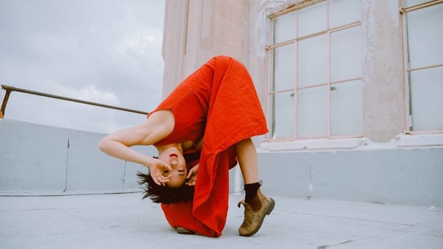 an Asian American woman looks through her fingers upside down