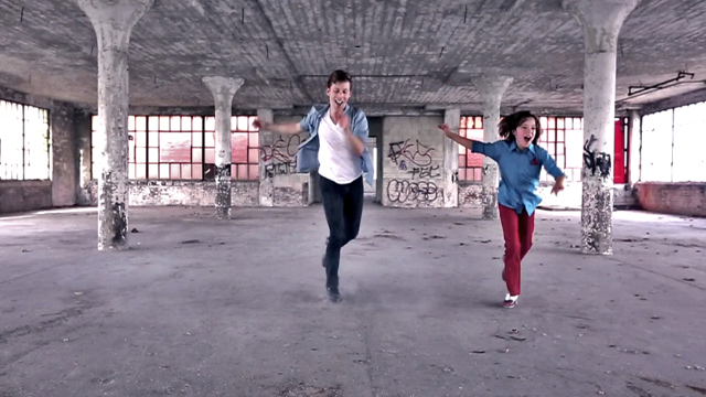 an older dancer and a younger dancer tapping in a graffiti filled warehouse