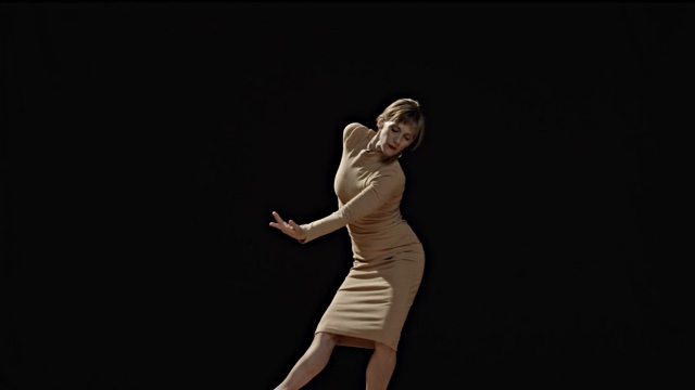 a dancer in a beige dress bend forward with her arm falling