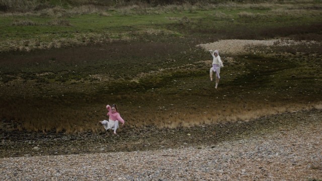 two dancers strike poses in a muddy meadow