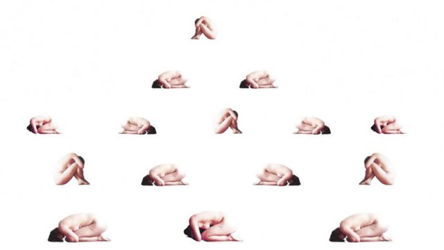 fifteen cut-outs of naked bodies holding knees to chest arranged on a solid white background