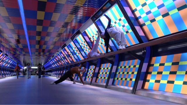 three dancers use the architecture of a brightly colored pedestrian tunnel to strike a pose while citizens go about their day nearby