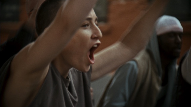a closeup of a protestor's face, mouth open as though yelling