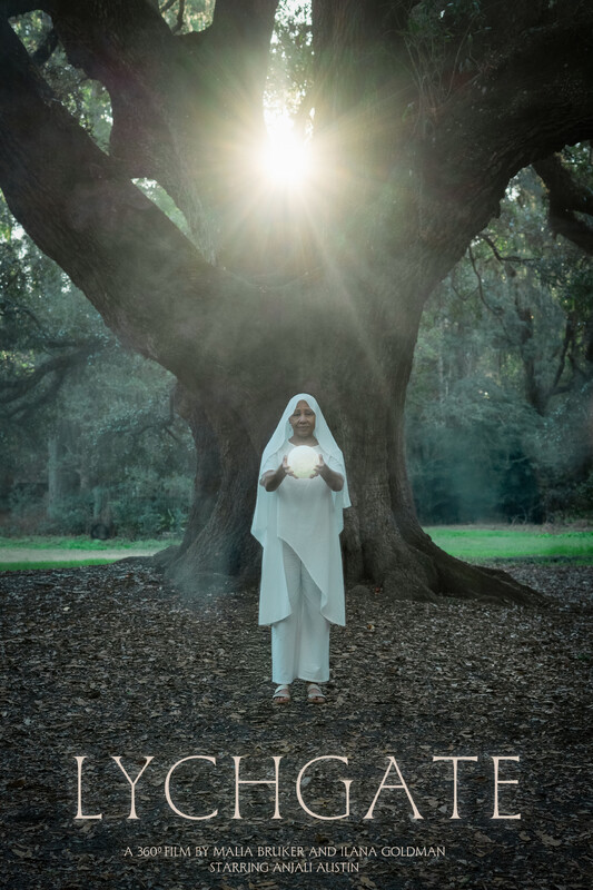 a woman wearing white flowing clothing holds a glowing orb; she is standing in front of a large tree, between the branches of which we see the setting sun, which glows just like the orb she holds